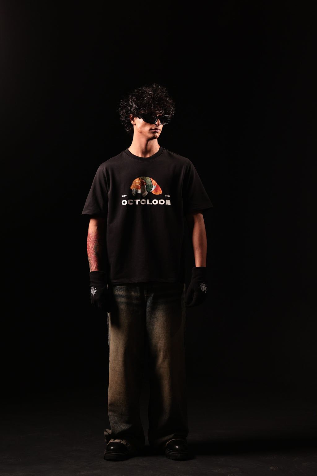Person wearing a black t-shirt with a graphic design on a black background