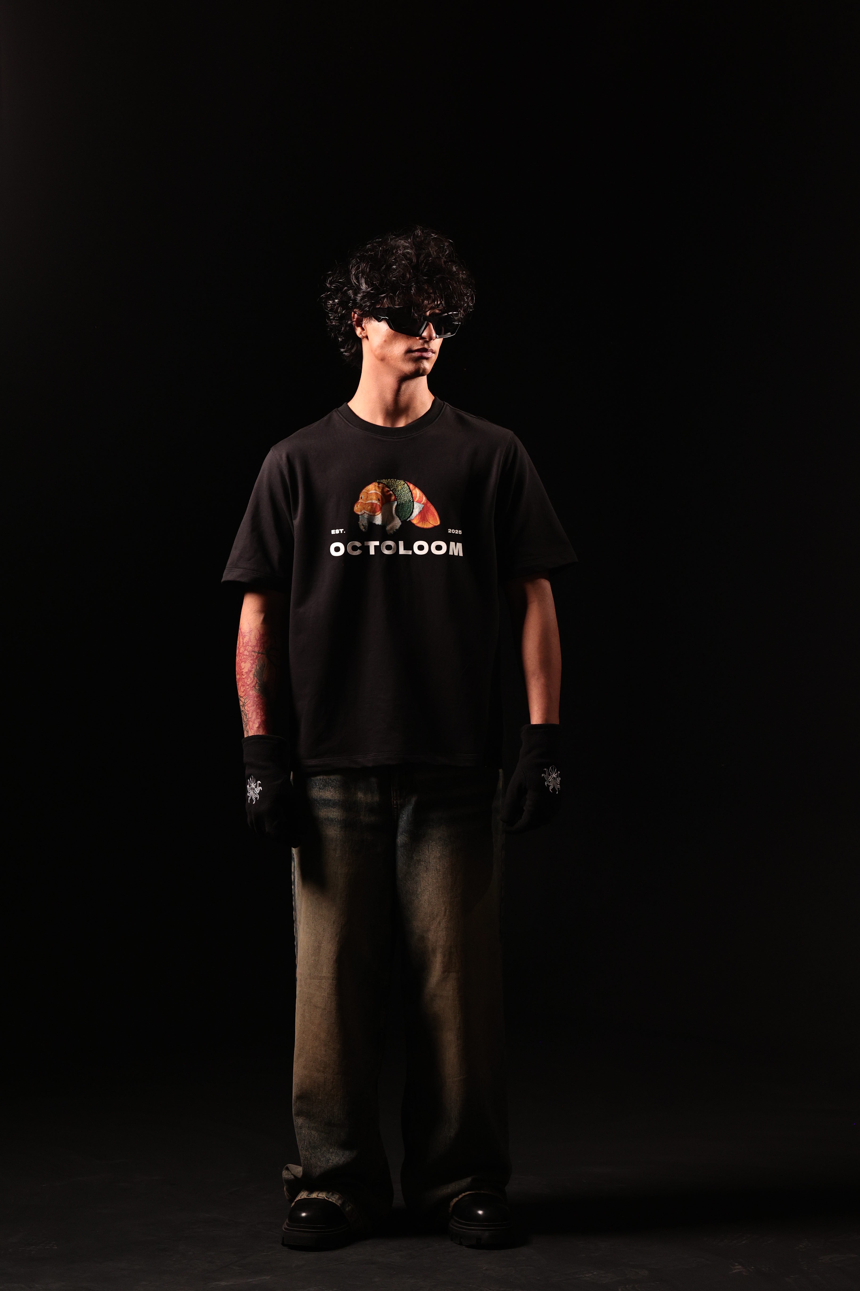 Person wearing a black t-shirt with a graphic design on a black background