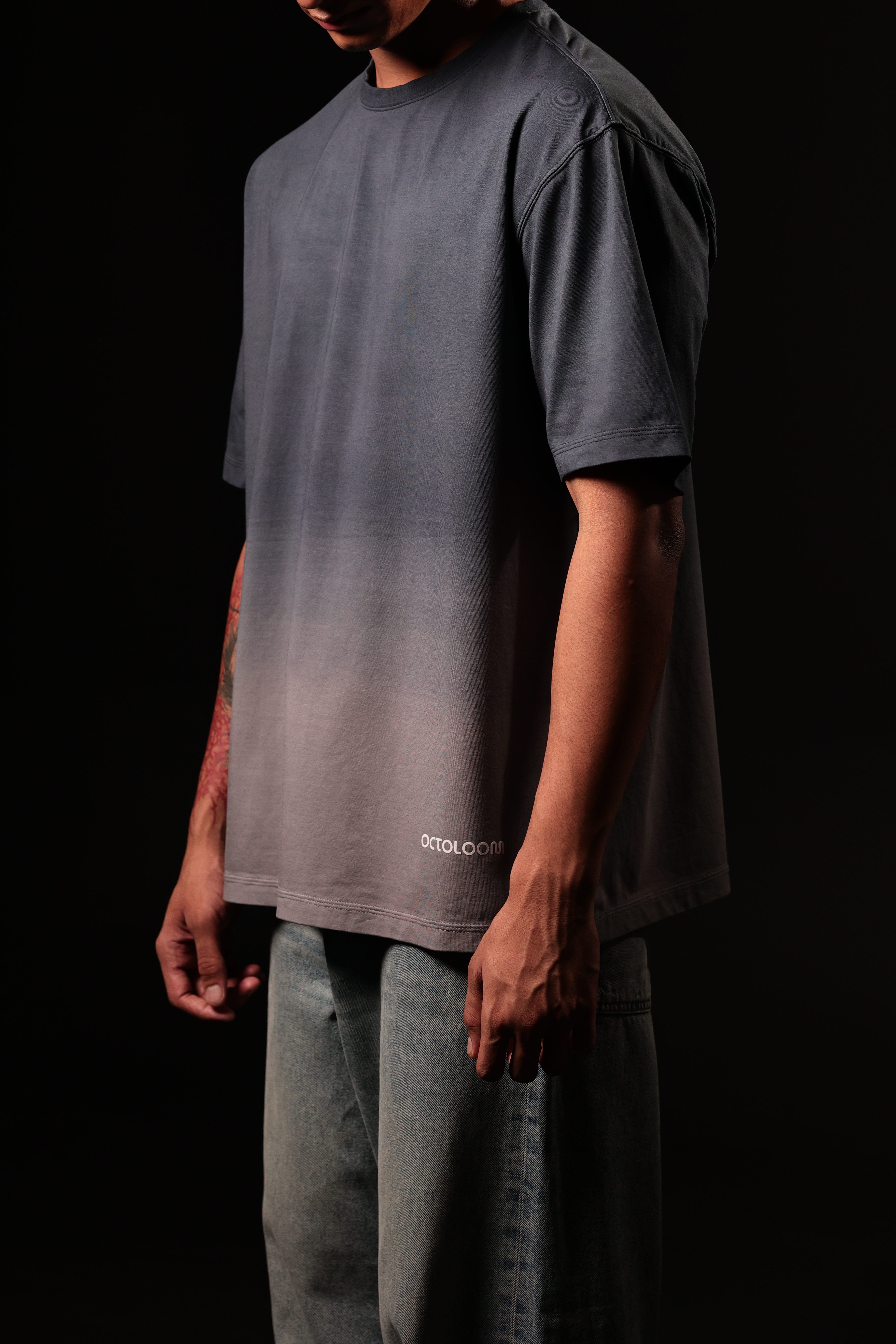 Person wearing a gray gradient t-shirt with 'Cotopaxi' branding on a black background