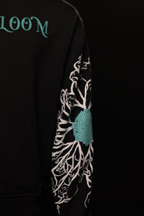 Black hoodie with floral design and 'LOOM' branding on sleeve against a black background