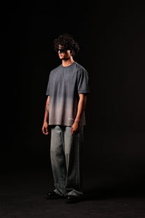 Person wearing a dark gray t-shirt and light gray pants against a black background