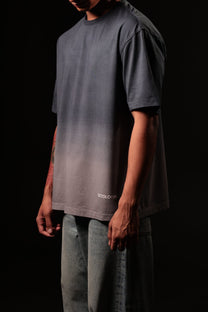 Person wearing a gray gradient t-shirt with 'Cotopaxi' branding on a black background