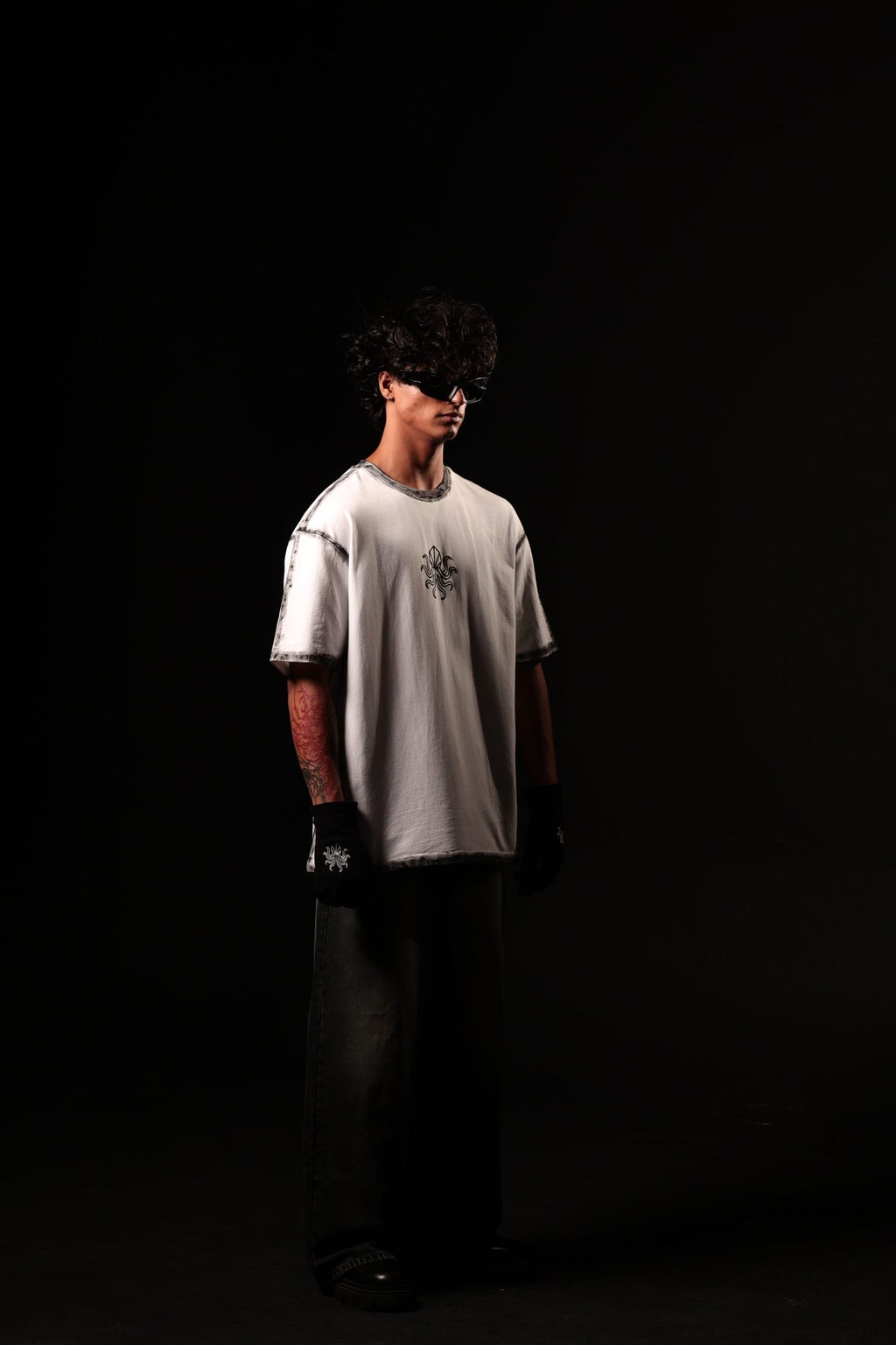 Person wearing a white t-shirt with a logo on a black background
