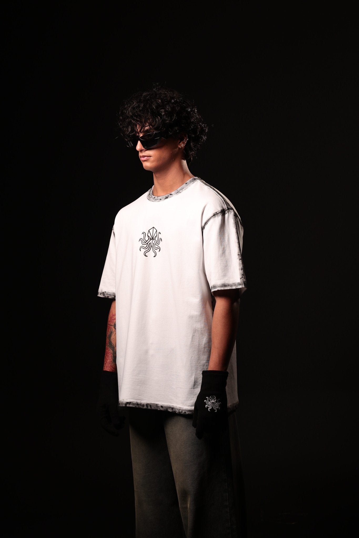 Person wearing a white oversized t-shirt with a design on a black background