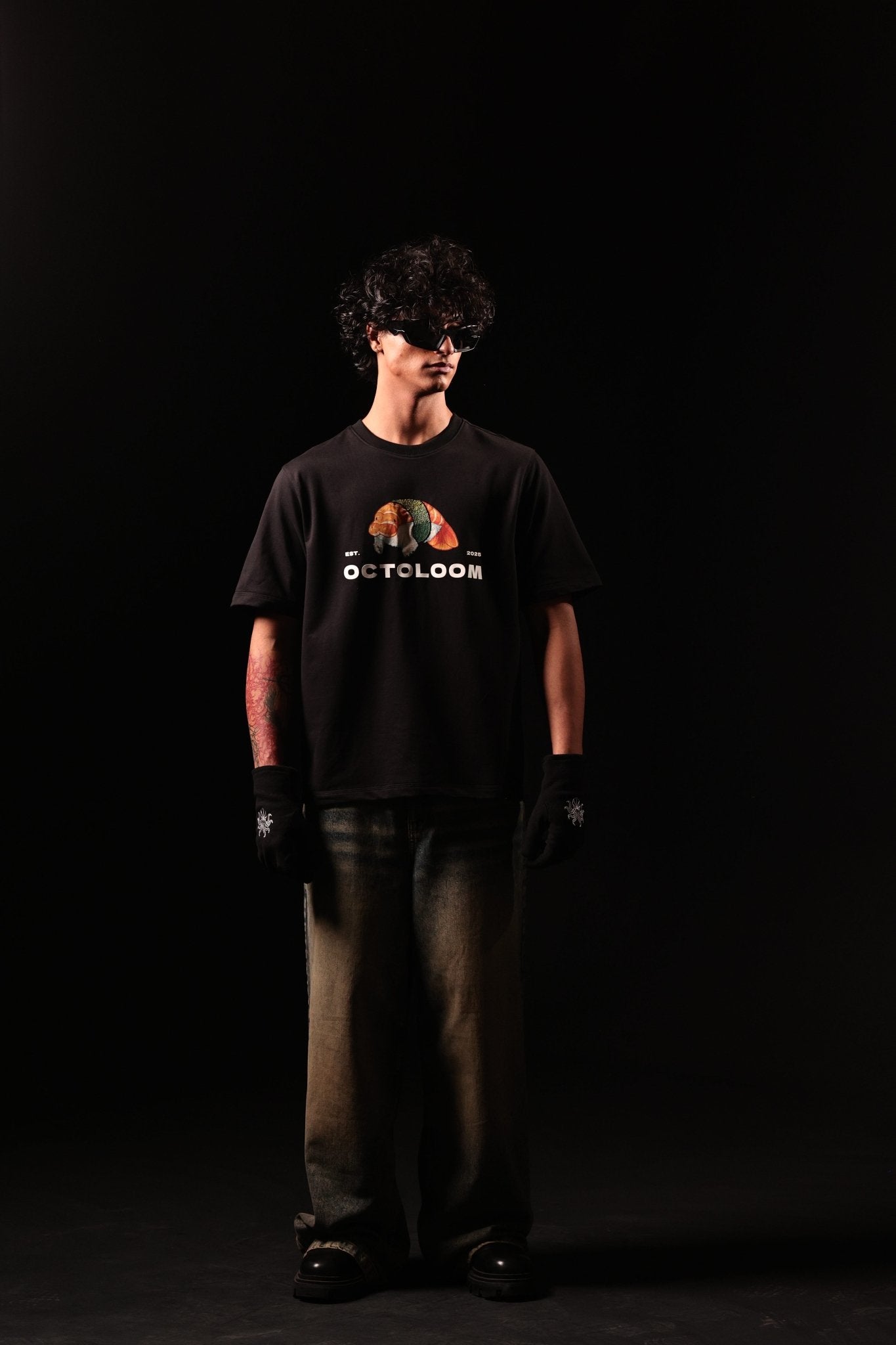 Person wearing a black t-shirt with a graphic design on a black background