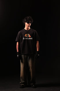 Person wearing a black t-shirt with a graphic design on a black background